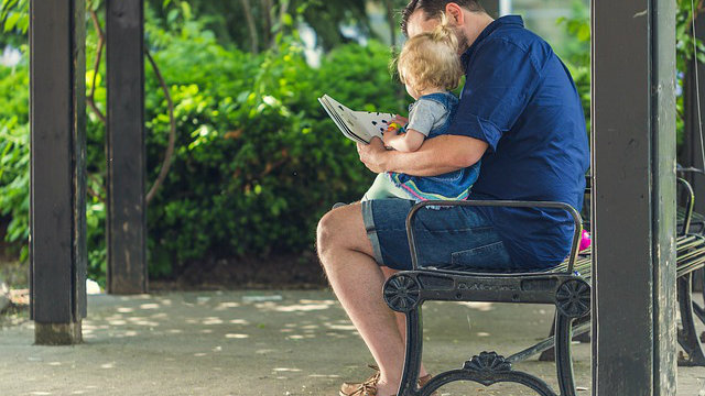 Father reading to child outside