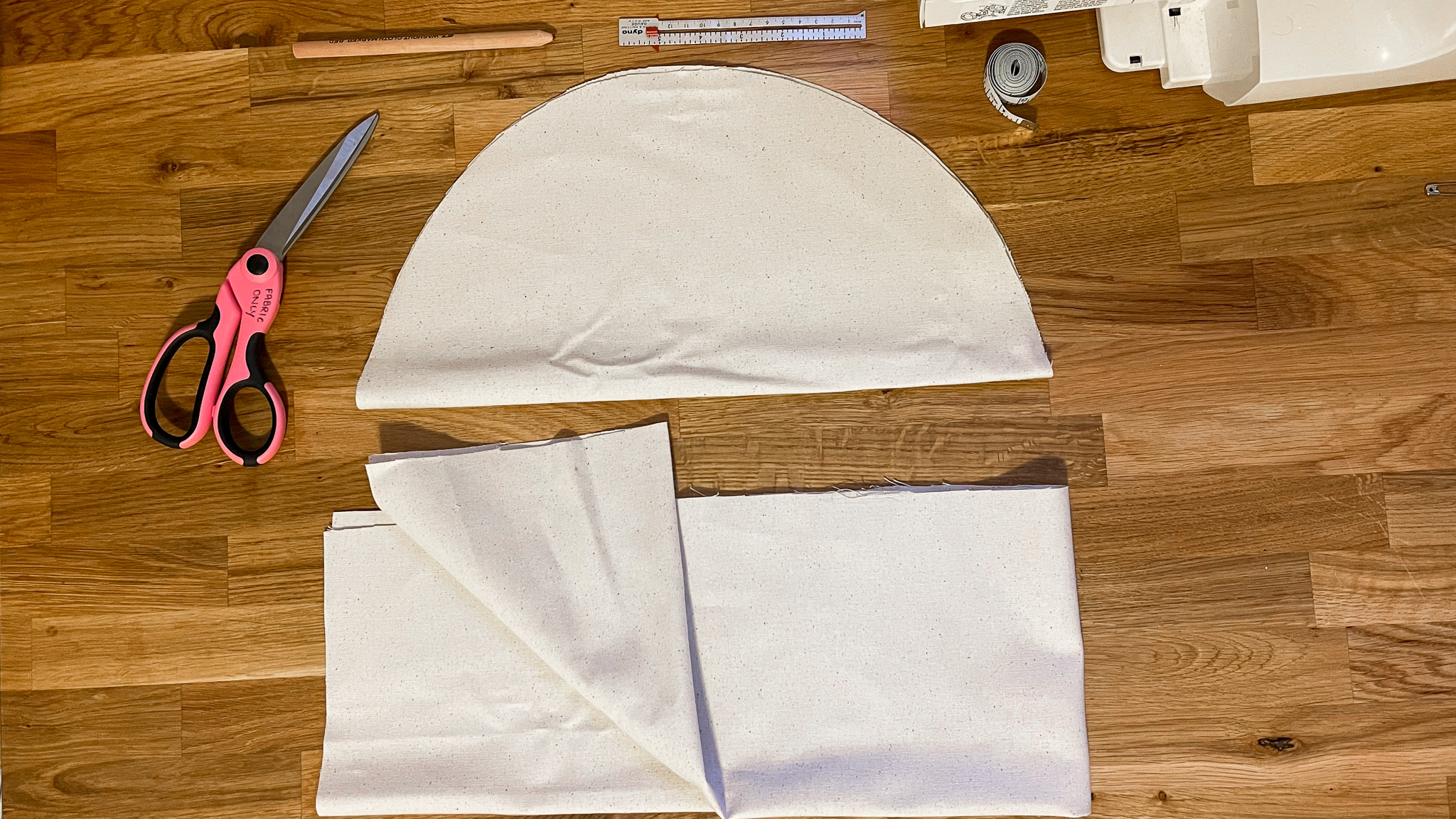 Simplay3's garden seat diy: fabric folded into a half circle and scissors getting ready to cut 