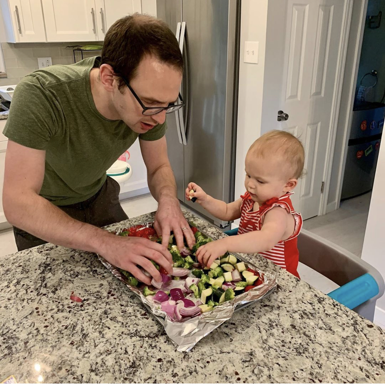 Simplay3: Cooking with your toddler, toddler is in a toddler tower to be able to reach the counter and help dad