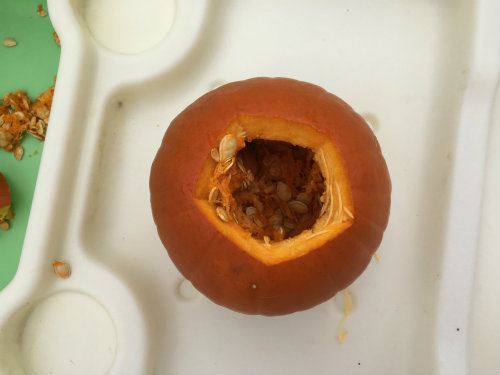 Use a spoon to loosen up the guts and seeds from the sides of the pumpkin
