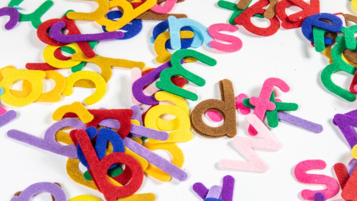 Simplay3's sensory sandbox ideas: alphabet letters made of felt and in all colors across a white background