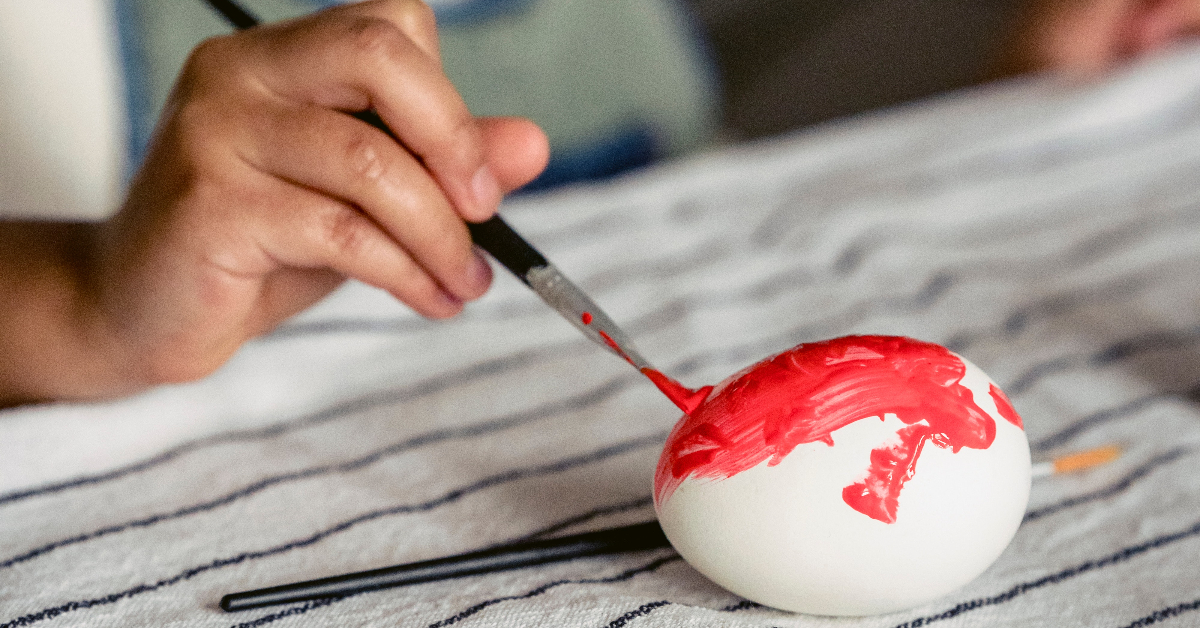 Simplay3's easy & unique ways to dye easter eggs: someone hand painting a egg red with a paintbrush