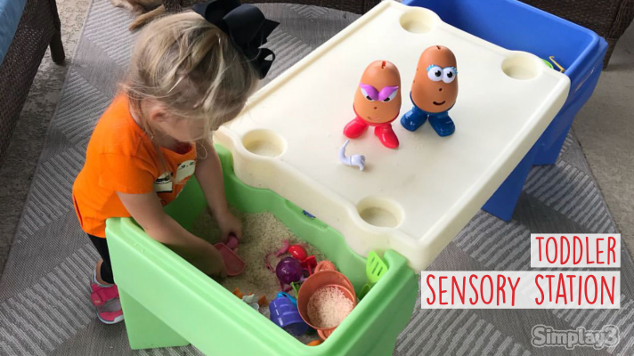 toddler sensory station for the home - child with an in & out activity table playing with sensory sand